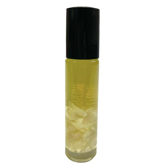 A white bottle with a white flower and a Rose Quartz Crystal Roller.