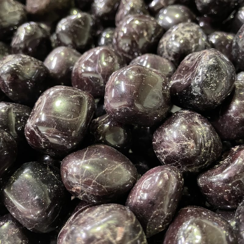 A close up of some garnet-colored Garnet Tumbled Crystal covered cherries.