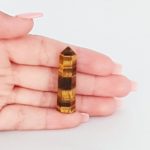 A person holding a Tigers Eye Mini Tower.
