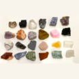 A variety of different colored Raw Crystal Collection Boxed are arranged on a white surface.