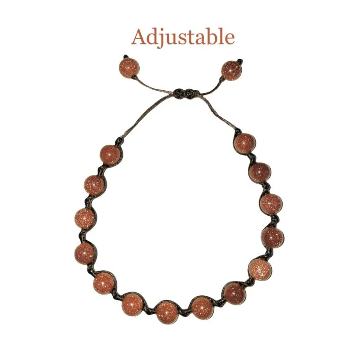 An adjustable Goldstone String Bracelet adorned with brown beads.