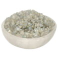 A bowl full of white pearls on a white surface, combined with the mesmerizing gleams of Aura Quartz Crystal Chips AAA Grade.