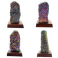 A group of colorful rocks on a wooden base, showcasing the Amethyst Aura Rainbow On Wood Base.