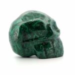 A Malachite Skull from South Africa on a white background.